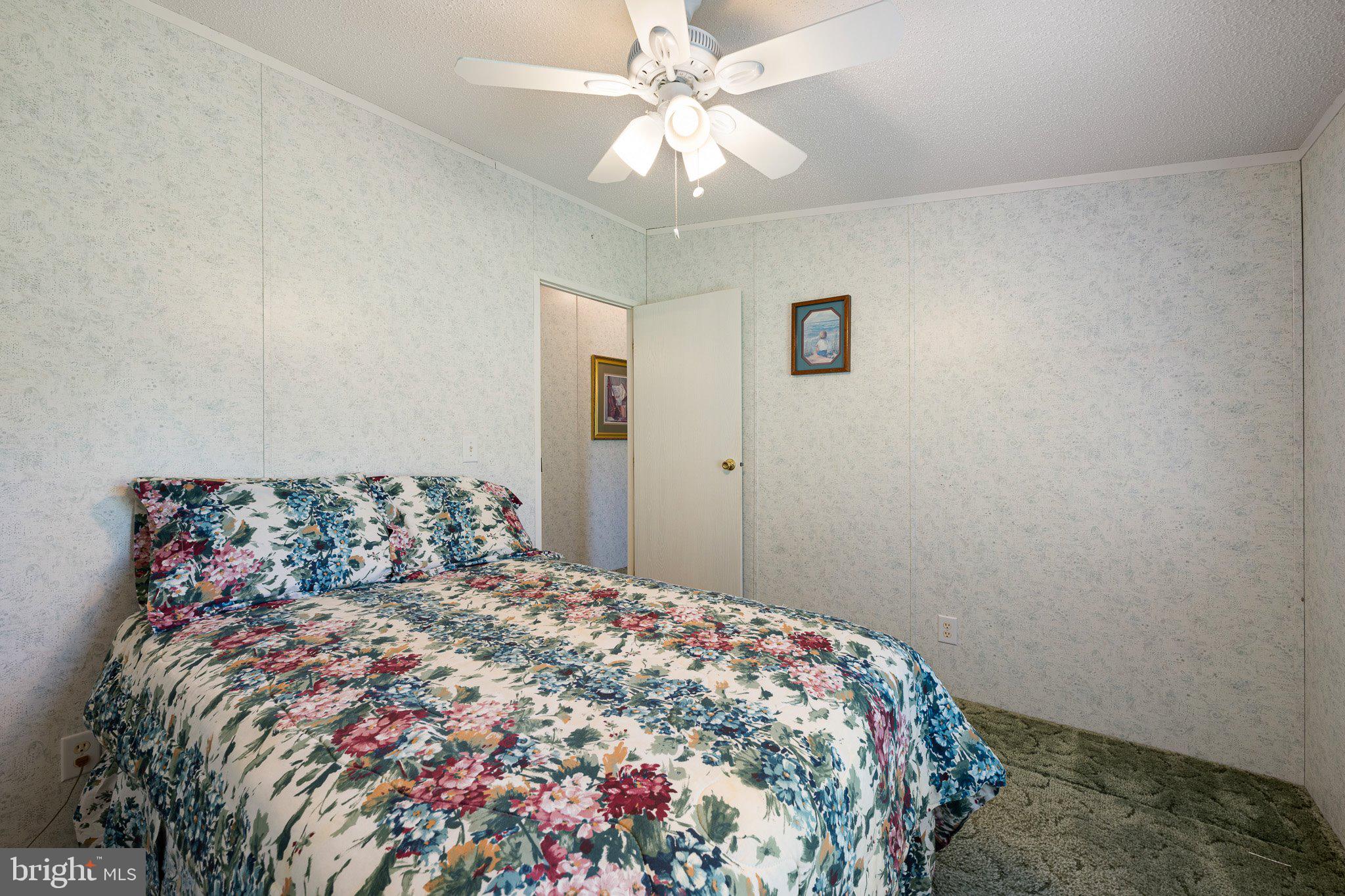 29044 Log Cabin Hill Road Lewes, DE 19958 - Photo 25 of 36 a bedroom with a bed and a chandelier