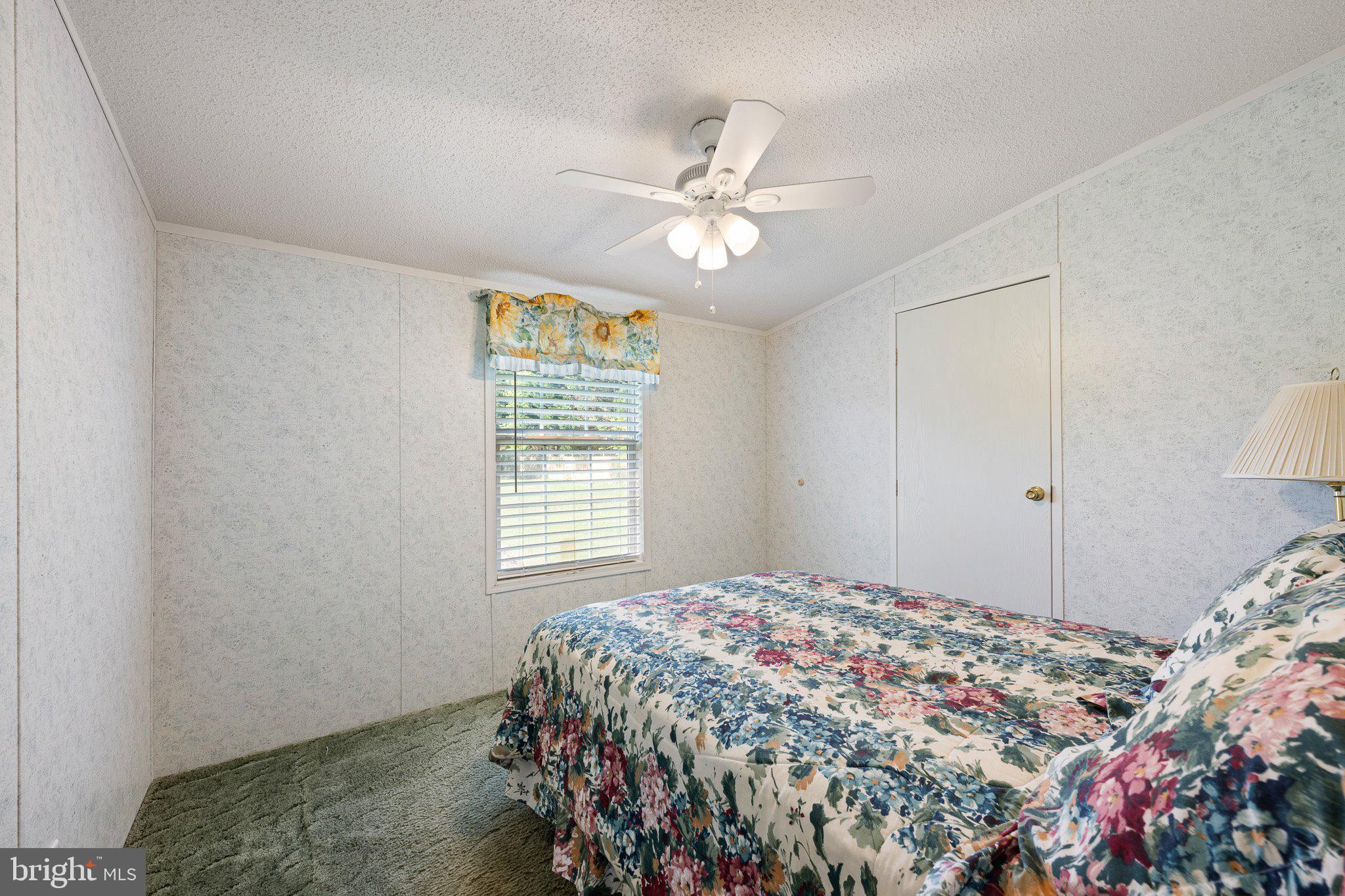 29044 Log Cabin Hill Road Lewes, DE 19958 - Photo 26 of 36 a bedroom with a bed and a chandelier