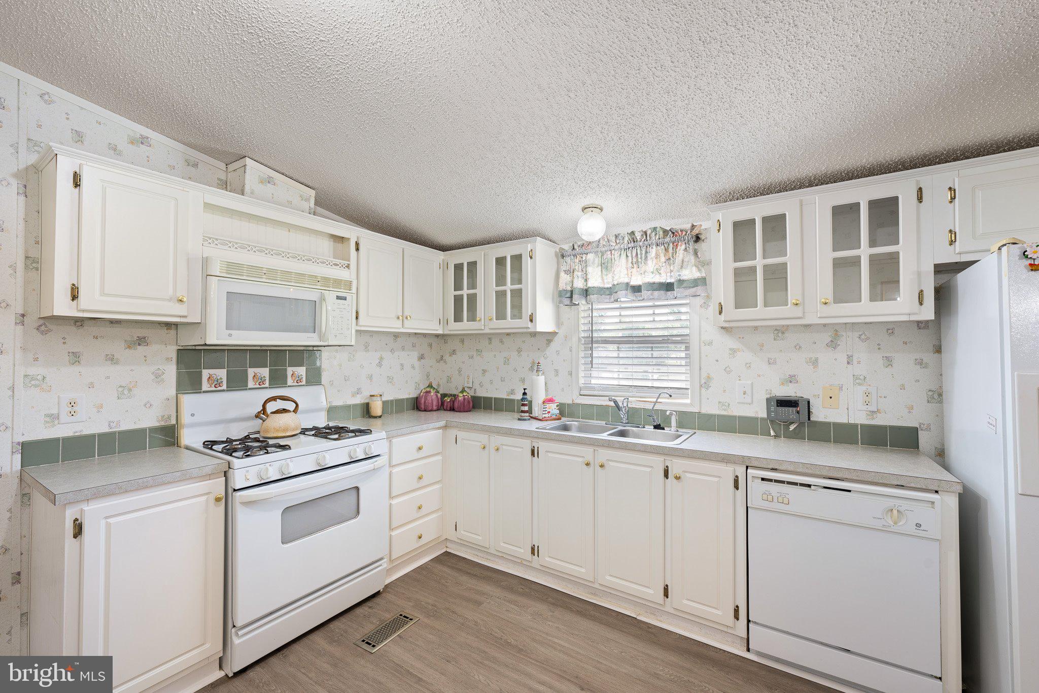 29044 Log Cabin Hill Road Lewes, DE 19958 - Photo 10 of 36 a kitchen with stainless steel appliances granite countertop a sink and cabinets with wooden floor