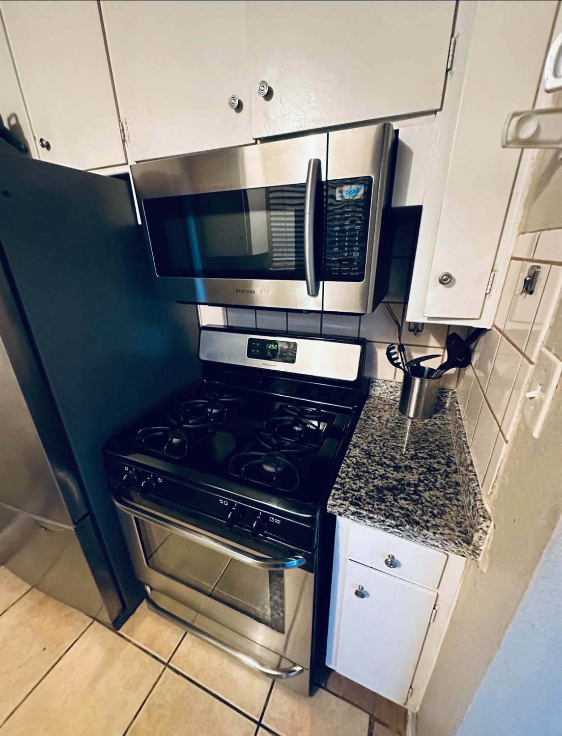 2045 Celeste Drive Modesto, CA 95355 - Photo 36 of 48 a kitchen with stainless steel appliances granite countertop a stove and a microwave