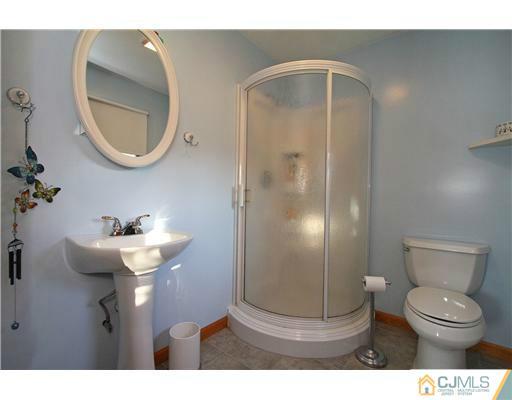 11 Butcher Road Monroe Township, NJ 08831 - Photo 12 of 18 a bathroom with a toilet sink and mirror
