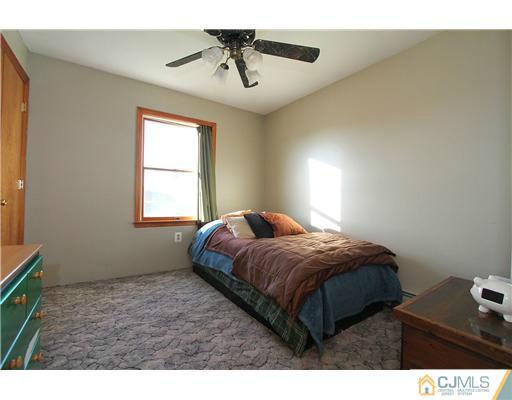 11 Butcher Road Monroe Township, NJ 08831 - Photo 17 of 18 a bedroom with a bed and window