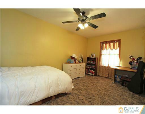 11 Butcher Road Monroe Township, NJ 08831 - Photo 18 of 18 a bedroom with a bed and a chandelier