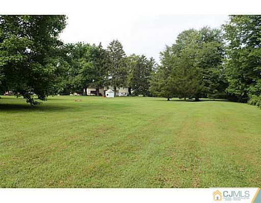 11 Butcher Road Monroe Township, NJ 08831 - Photo 6 of 18 a view of a field with an trees in the background