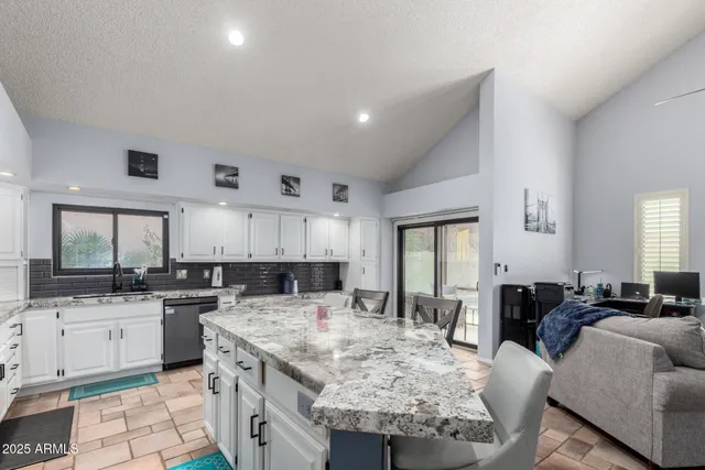 a kitchen with granite countertop a sink and cabinets