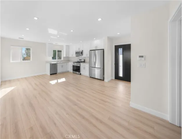 a view of a kitchen with wooden floor and electronic appliances