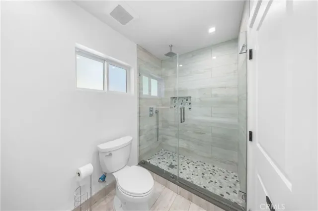 a bathroom with a toilet and a shower