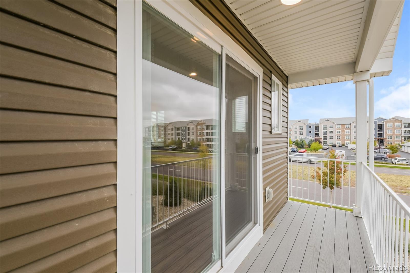 5383 Andes Street Denver, CO 80249 - Photo 13 of 18 a view of a balcony with floor to ceiling window wooden floor with brick wall