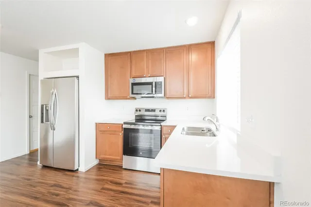a kitchen with granite countertop wooden floors and stainless steel appliances