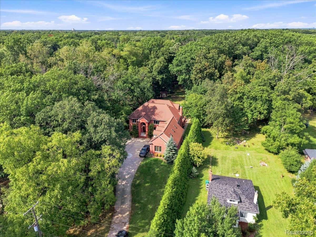 8610 Ferry Road Grosse Ile, MI 48138 - Photo 2 of 55 Brick exterior residence with a multi-gabled roof, surrounded by mature trees