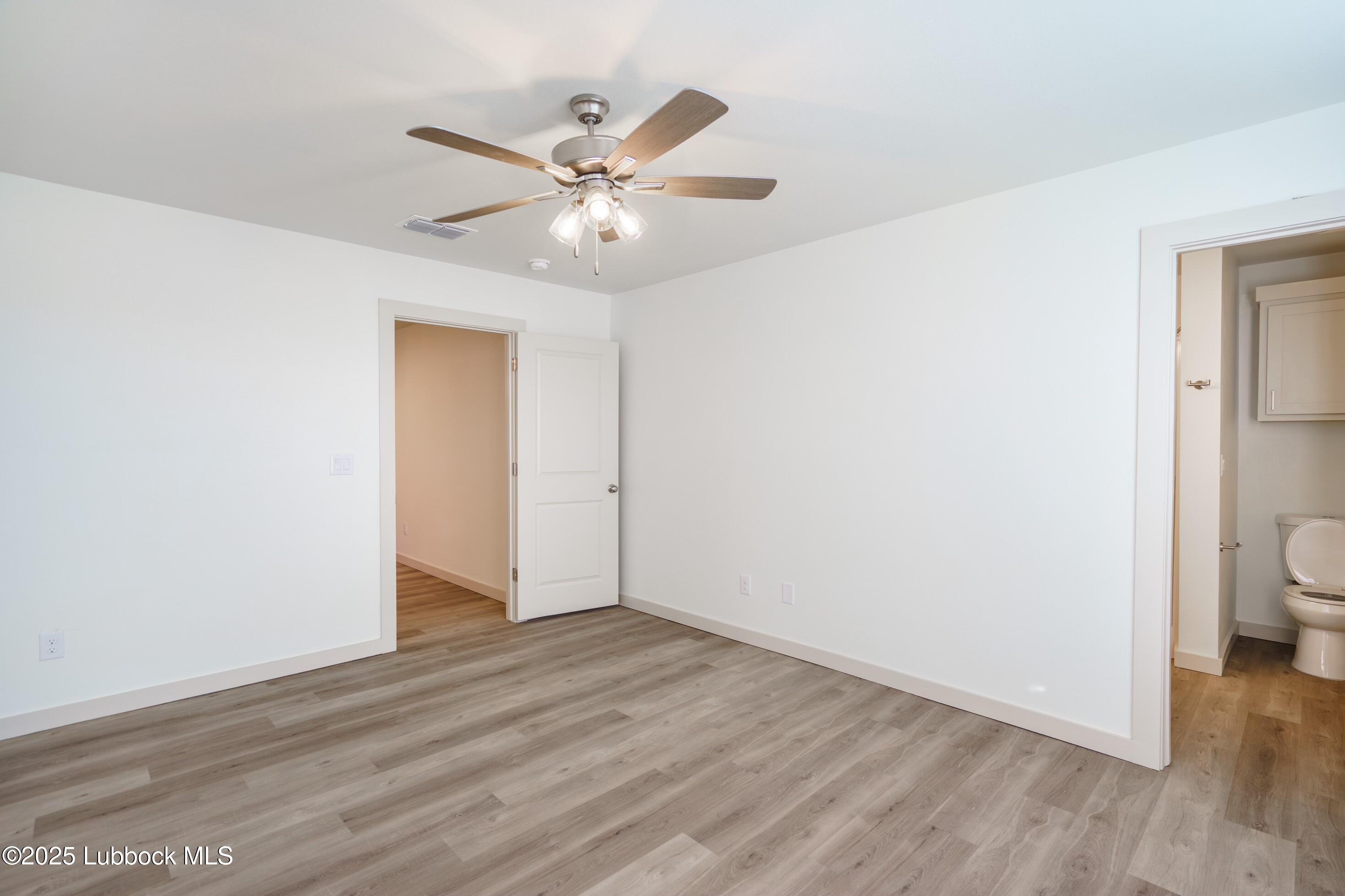8025 Date Avenue Lubbock, TX 79404 - Photo 6 of 12 a view of a room with wooden floor and a ceiling fan