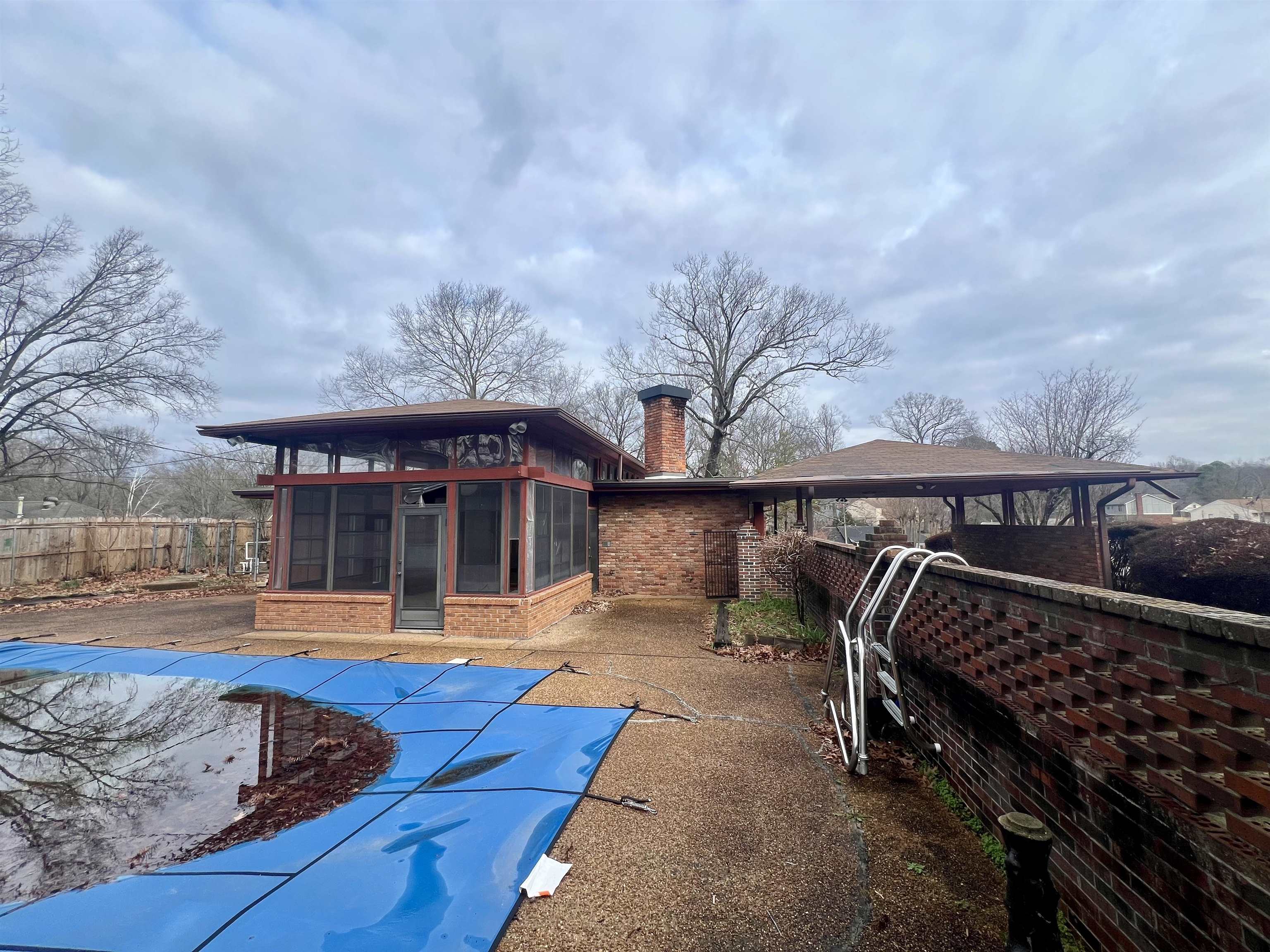 3153 Kirkcaldy Road Memphis, TN 38128 - Photo 20 of 28 Back of property with a chimney, a sunroom, a fenced backyard, and brick siding