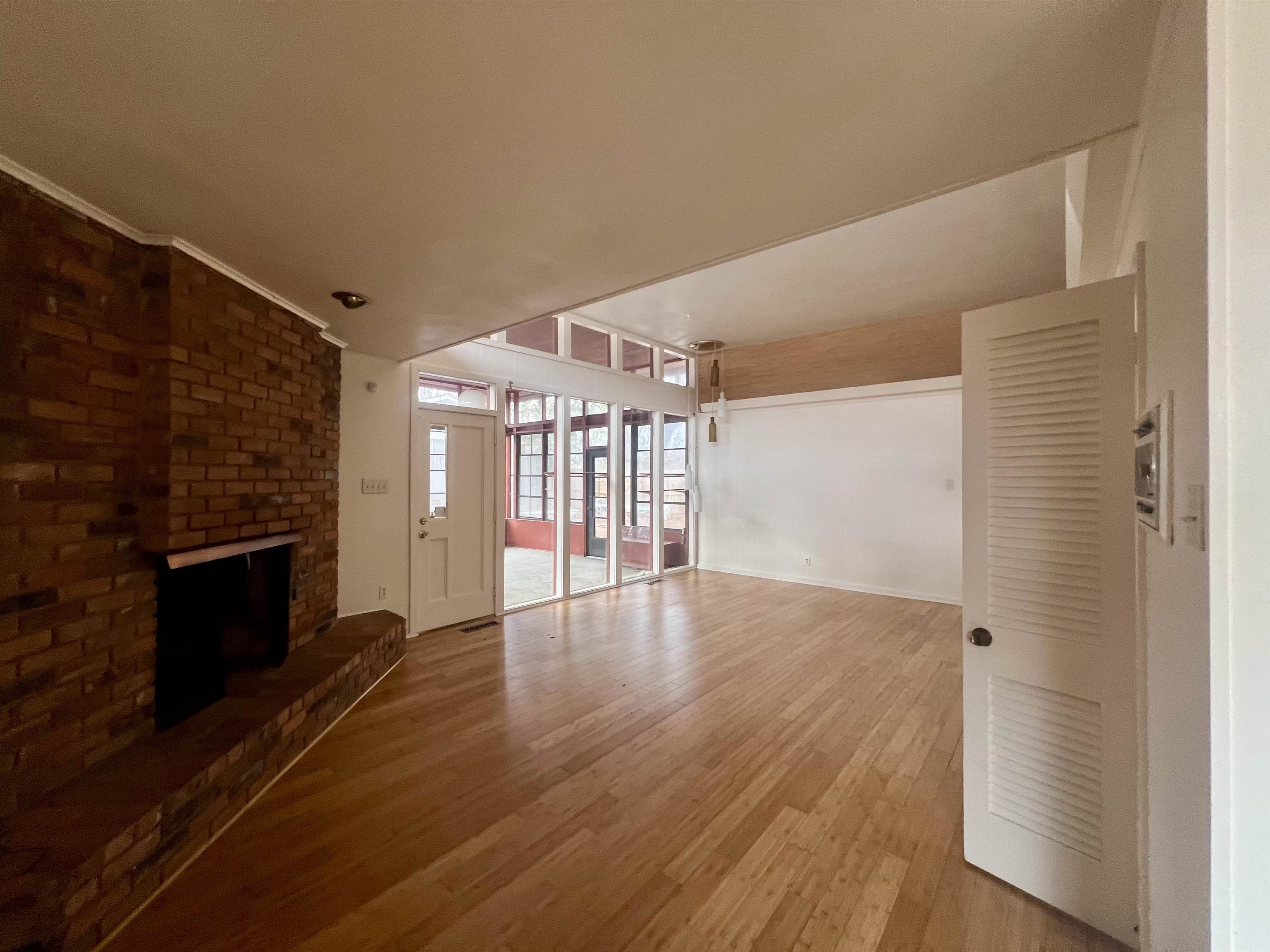 3153 Kirkcaldy Road Memphis, TN 38128 - Photo 2 of 28 Unfurnished living room with wood-type flooring, a brick fireplace, and ornamental molding