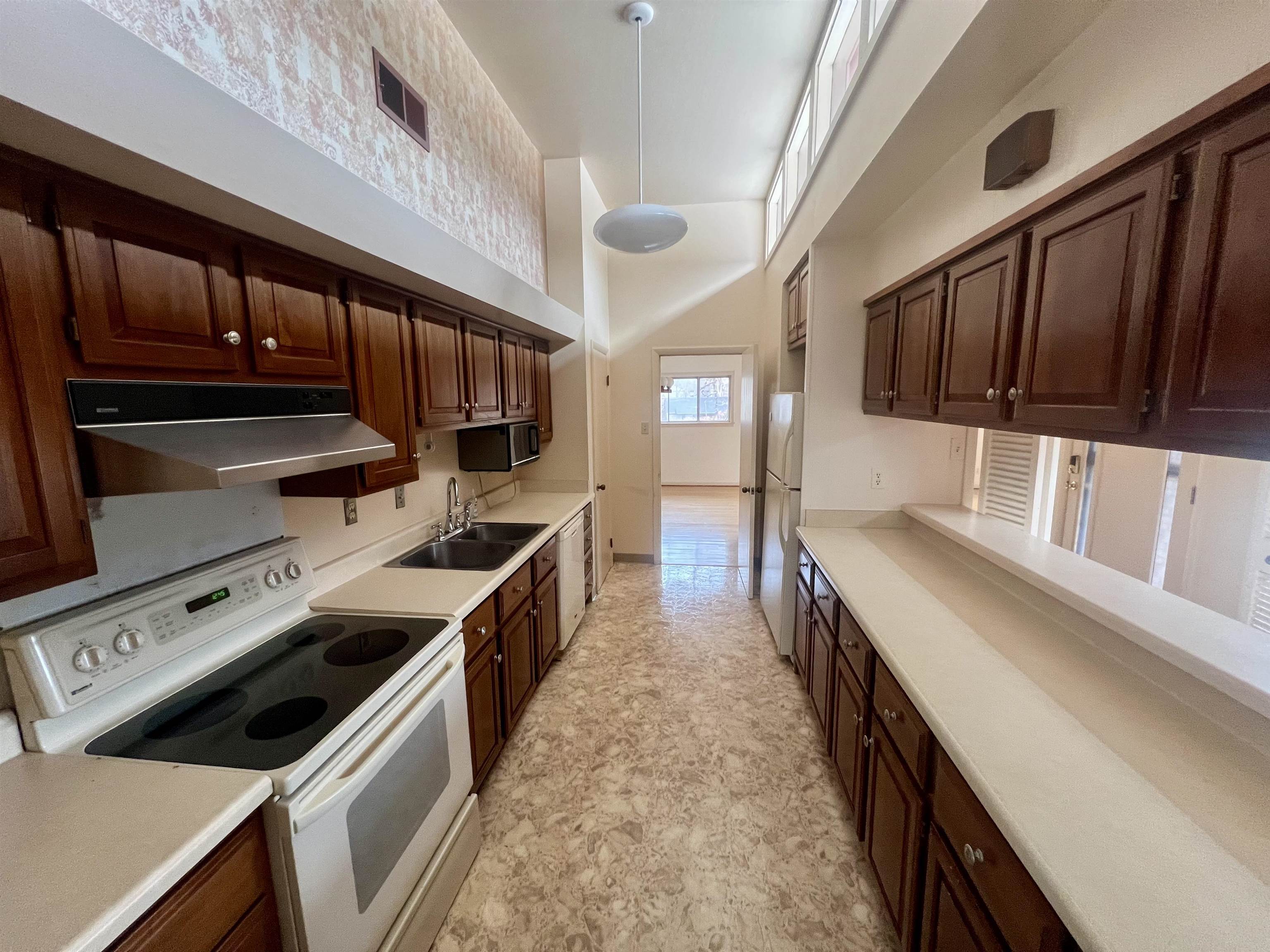 3153 Kirkcaldy Road Memphis, TN 38128 - Photo 24 of 28 Kitchen with white appliances, dark wood finish cabinets, light countertops, hanging light fixtures, and a high ceiling