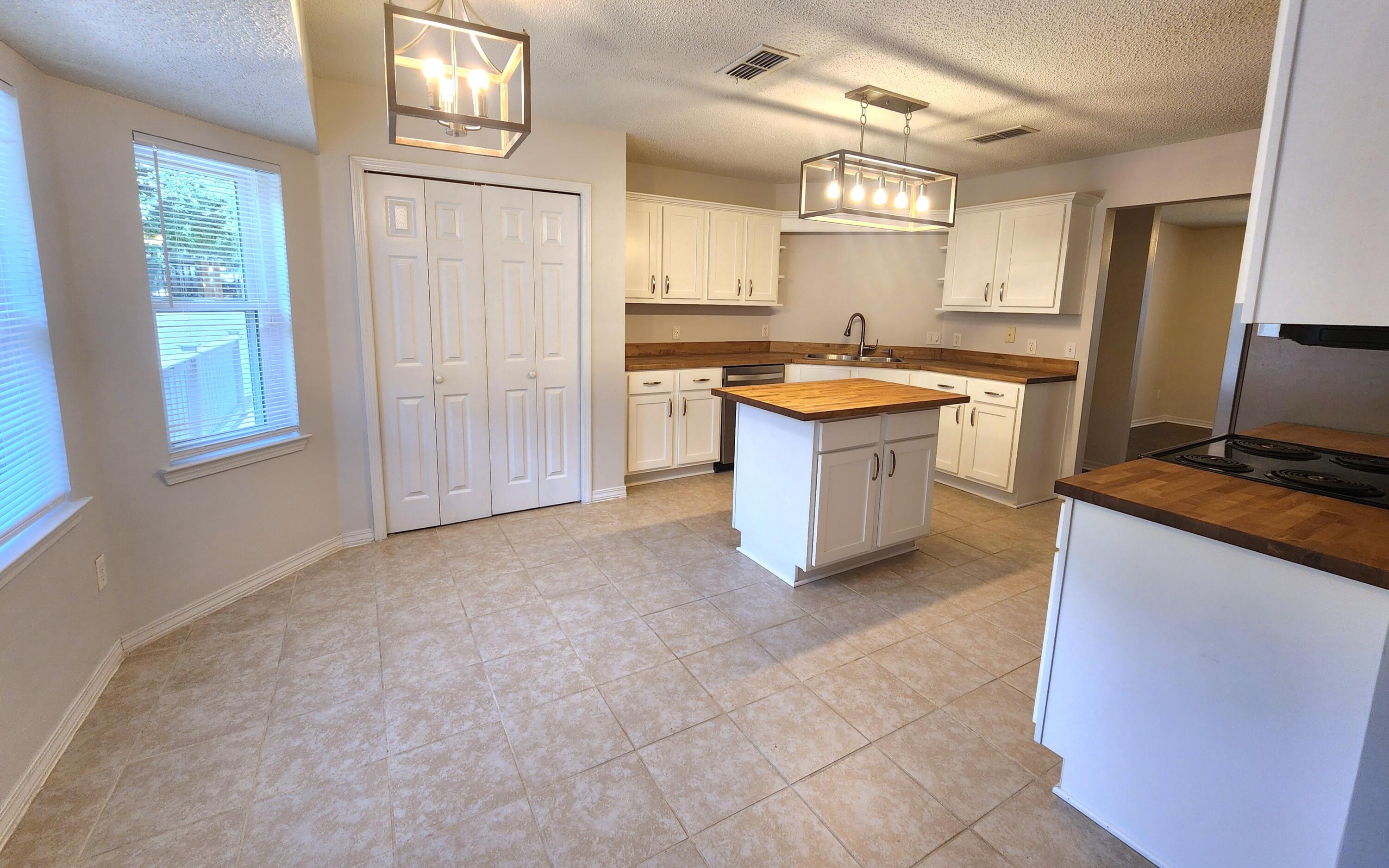 316 Egan Drive Crestview, FL 32536 - Photo 13 of 32 a large kitchen with kitchen island a sink stainless steel appliances and cabinets