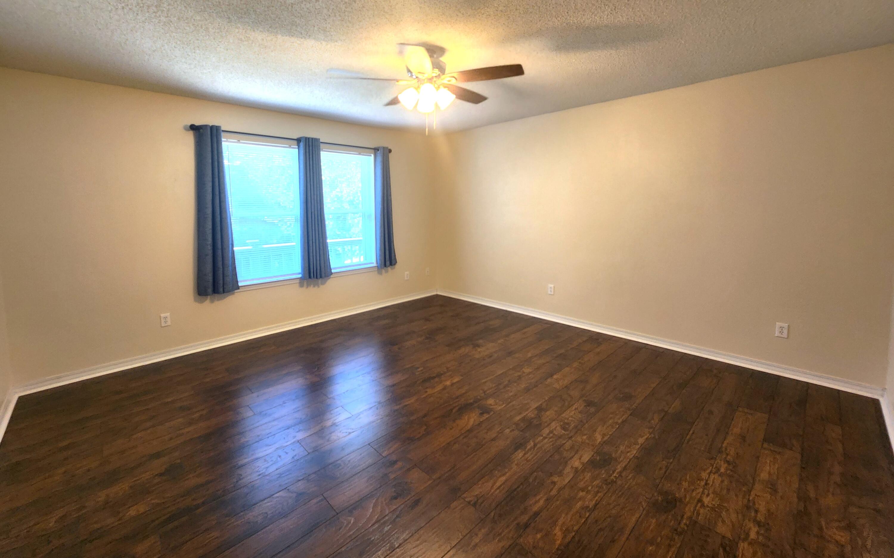316 Egan Drive Crestview, FL 32536 - Photo 16 of 32 a view of an empty room with window and wooden floor