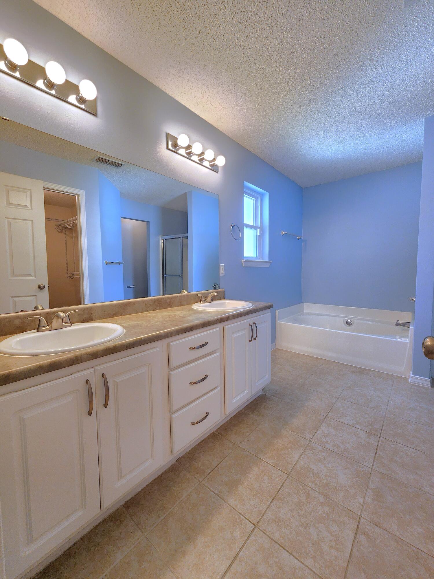 316 Egan Drive Crestview, FL 32536 - Photo 17 of 32 a spacious bathroom with a granite countertop sink a mirror and a