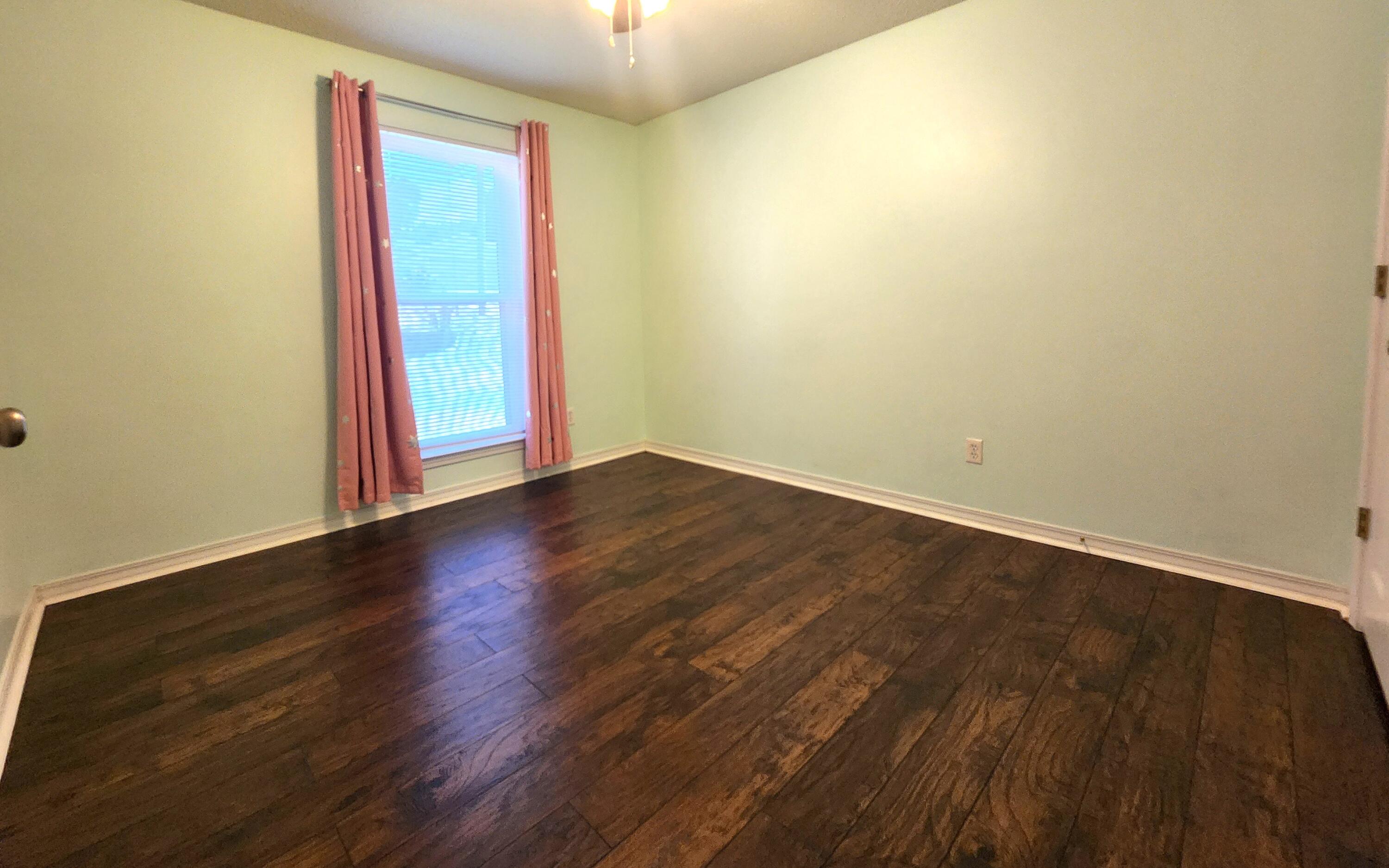 316 Egan Drive Crestview, FL 32536 - Photo 22 of 32 an empty room with wooden floor and windows