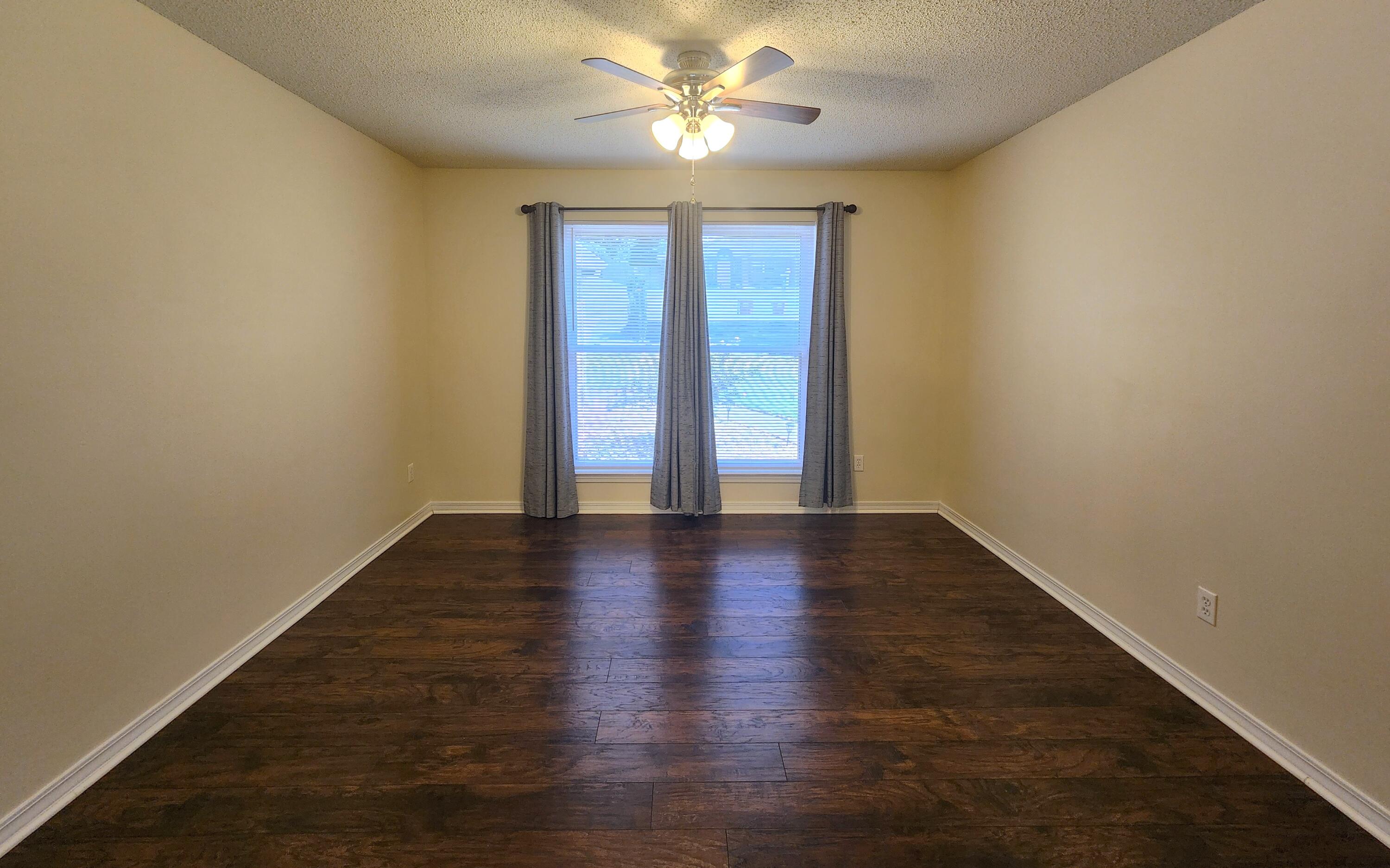 316 Egan Drive Crestview, FL 32536 - Photo 7 of 32 a view of an empty room with window and wooden floor