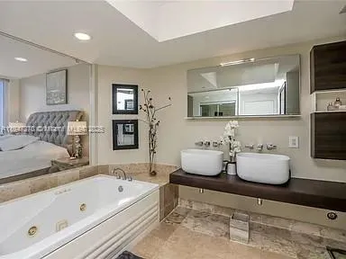 a bathroom with a tub sink and mirror