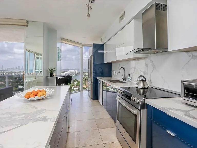4775 Collins Avenue, Unit 2105 Miami Beach, FL 33140 - Photo 12 of 21 a kitchen with stainless steel appliances granite countertop a sink stove and cabinets