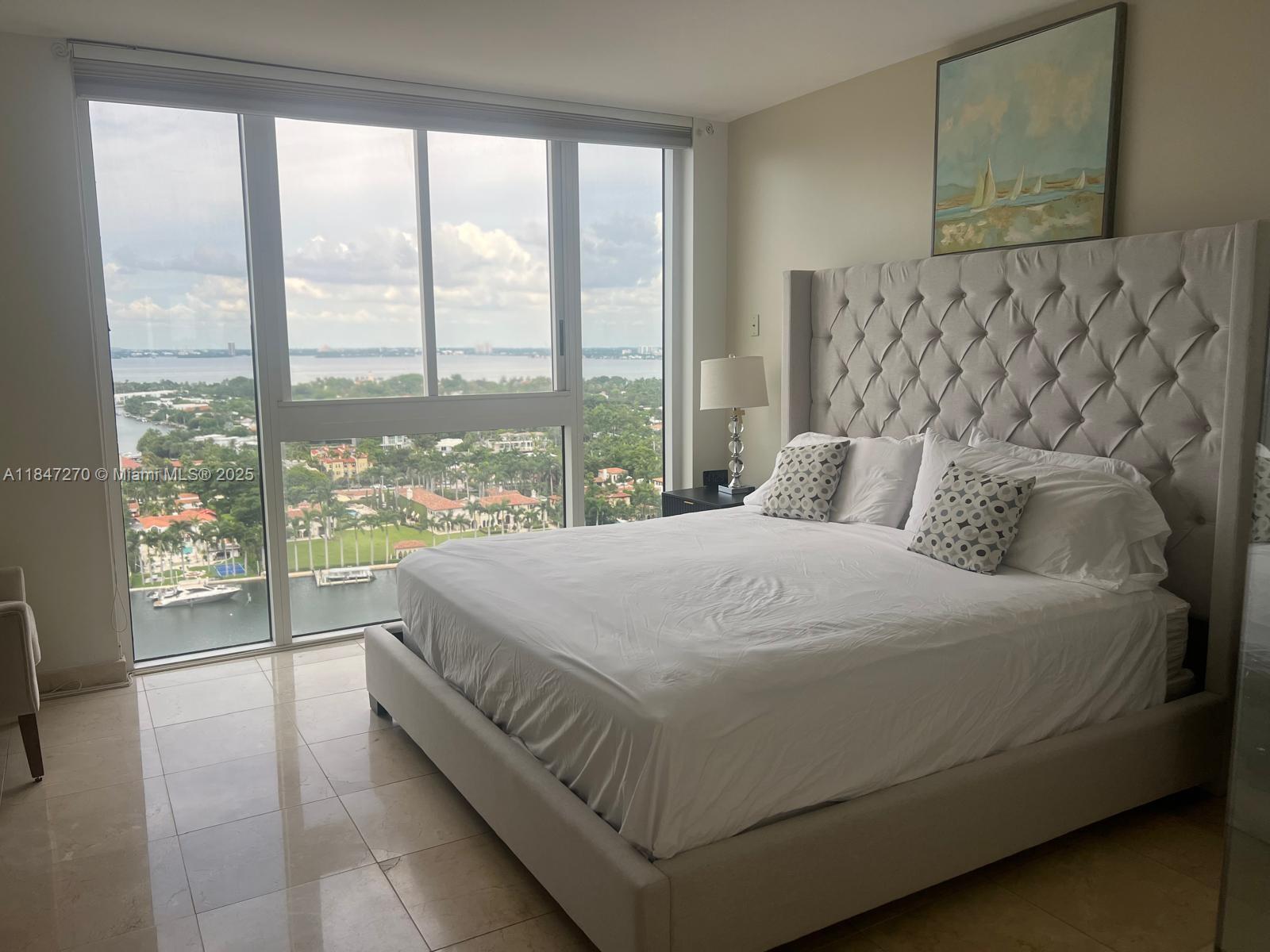 4775 Collins Avenue, Unit 2105 Miami Beach, FL 33140 - Photo 15 of 21 a large bed sitting in a bedroom next to a large window