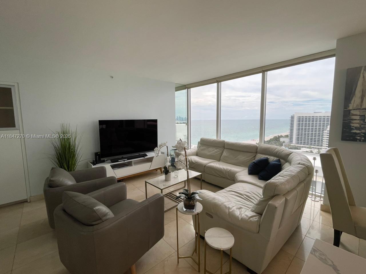 4775 Collins Avenue, Unit 2105 Miami Beach, FL 33140 - Photo 20 of 21 a living room with furniture and a flat screen tv