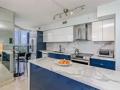 a kitchen with a stove a sink and chairs