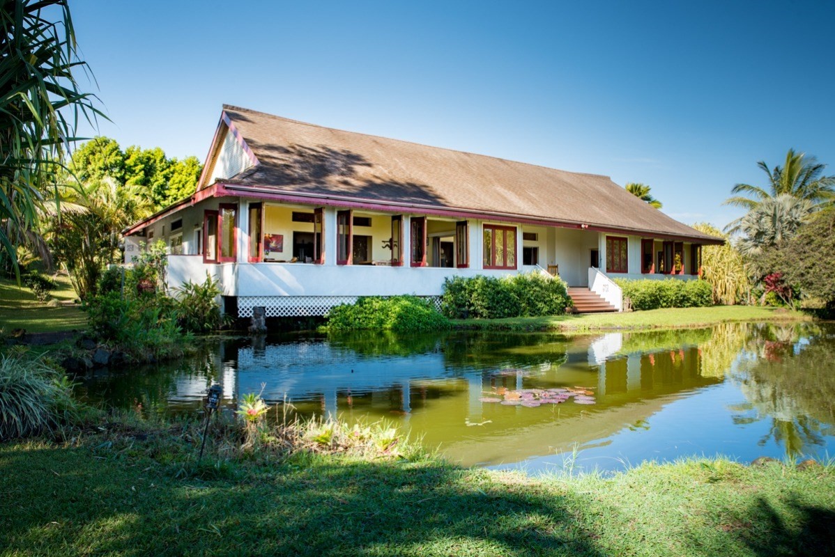 a front view of a house with a yard and potted plants