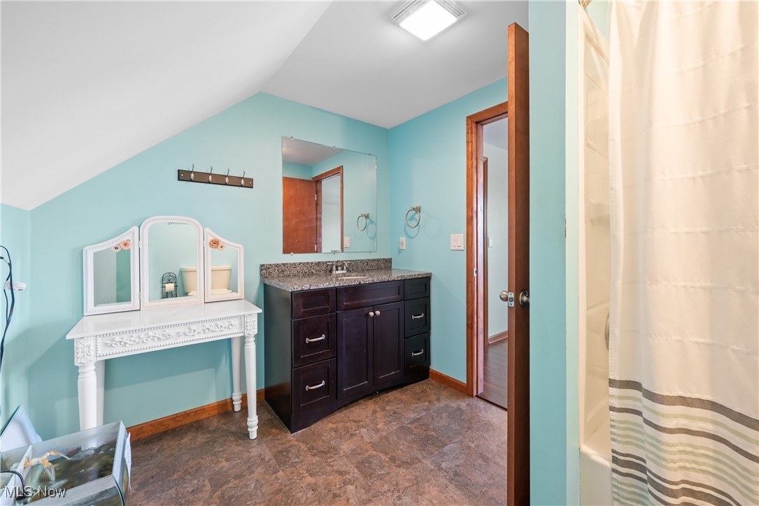 399 Wilder Road Vinton, OH 45686 - Photo 24 of 36 Full bathroom featuring vanity, shower / bath combo with shower curtain, stone finish flooring, and lofted ceiling