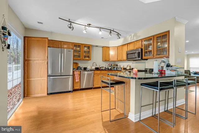 a kitchen with stainless steel appliances granite countertop a sink stove and cabinets