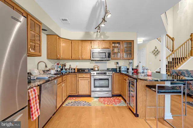 a kitchen with stainless steel appliances granite countertop a sink stove and cabinets