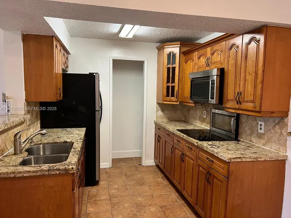a kitchen with stainless steel appliances granite countertop a refrigerator a stove top oven a sink and dishwasher