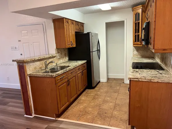 a kitchen with stainless steel appliances granite countertop a stove a refrigerator and a refrigerator