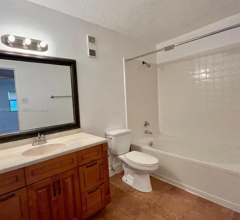 a bathroom with a sink a toilet a mirror and shower