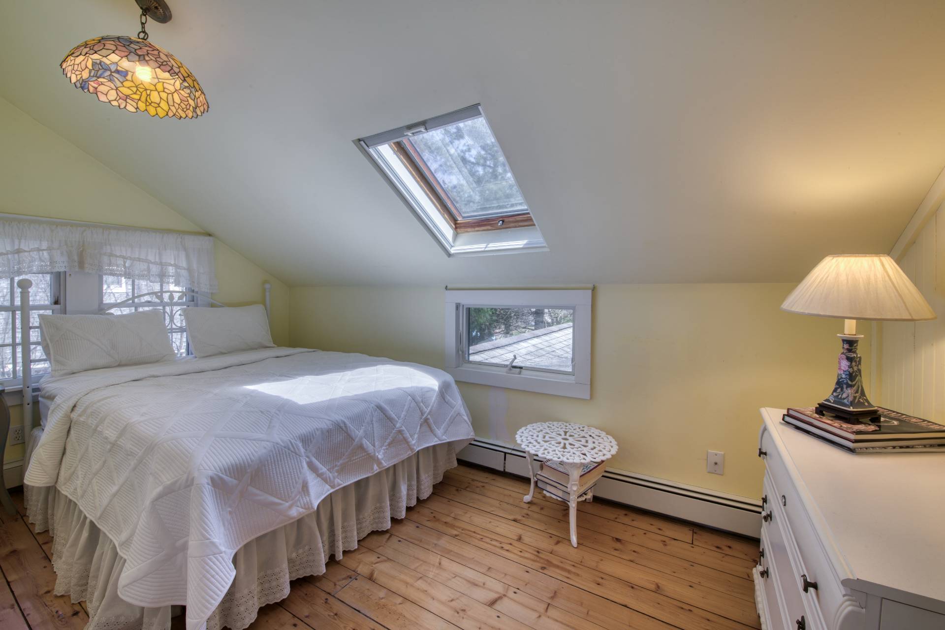 201 Three Mile Harbor Road East Hampton, NY 11937 - Photo 17 of 19 a bedroom with a bed and a lamp on dresser with wooden floor
