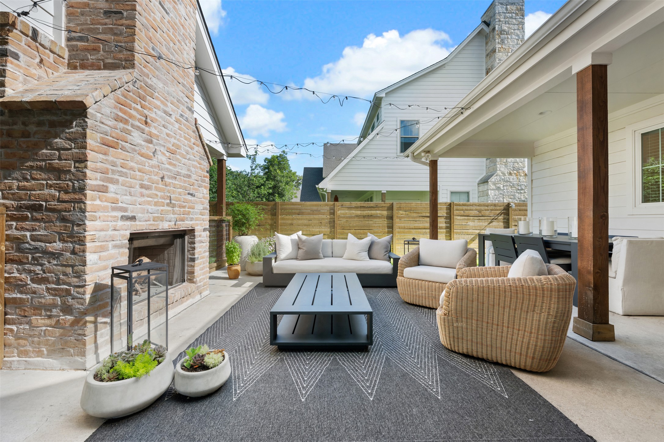 1301 West Street Georgetown, TX 78626 - Photo 37 of 40 An inviting outdoor living space features a brick fireplace, covered patio, and wooden privacy fence.
