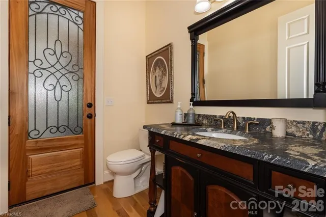 a bathroom with a granite countertop toilet sink and mirror