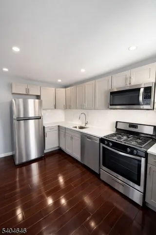 a kitchen with stainless steel appliances a stove a sink and a refrigerator