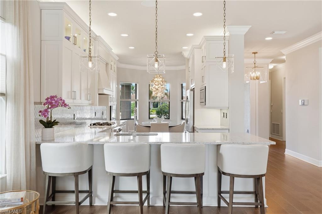 4220 Amelia Way Naples, FL 34119 - Photo 11 of 50 a large kitchen with a table and chairs