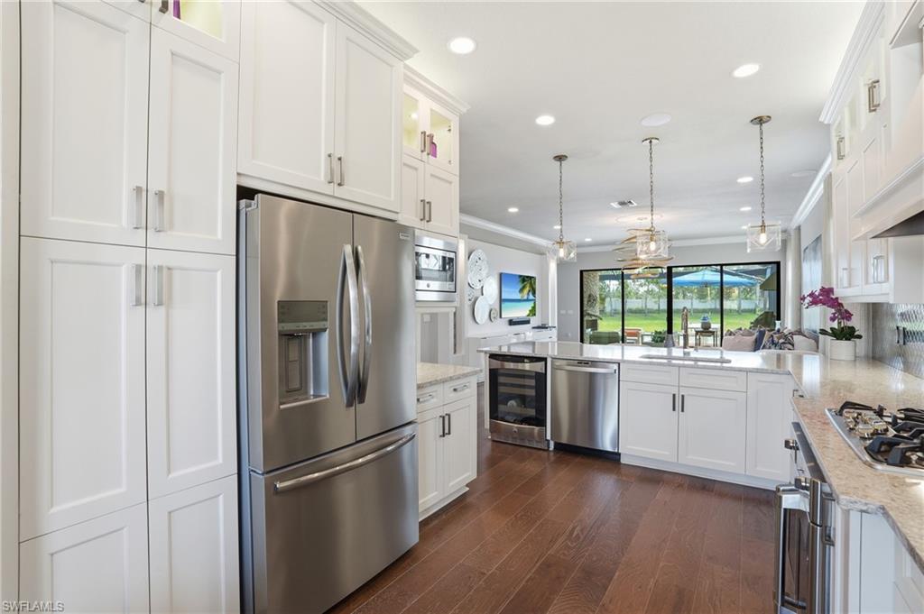 4220 Amelia Way Naples, FL 34119 - Photo 14 of 50 a kitchen with kitchen island granite countertop appliances cabinets and a sink