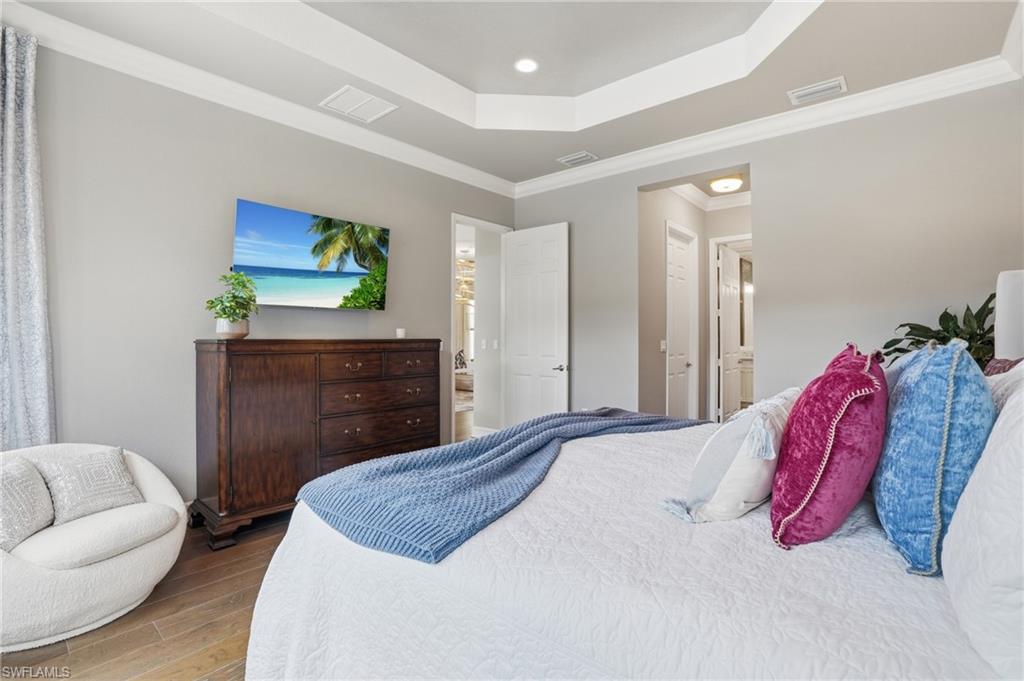 4220 Amelia Way Naples, FL 34119 - Photo 19 of 50 a bedroom with a bed and a dresser