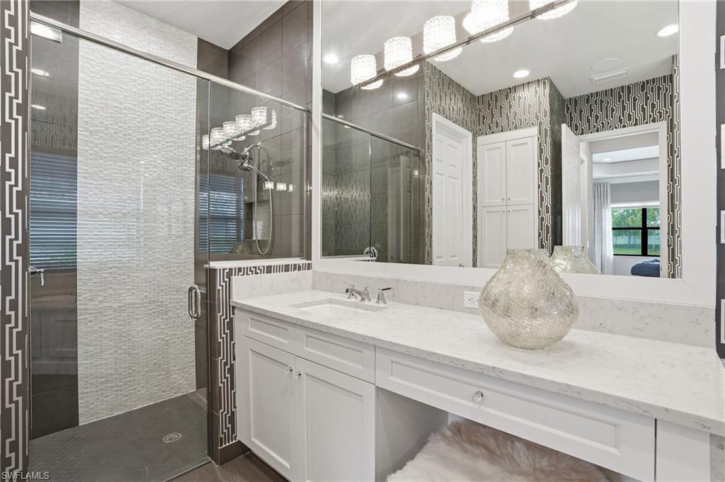 4220 Amelia Way Naples, FL 34119 - Photo 21 of 50 a bathroom with a sink and a mirror