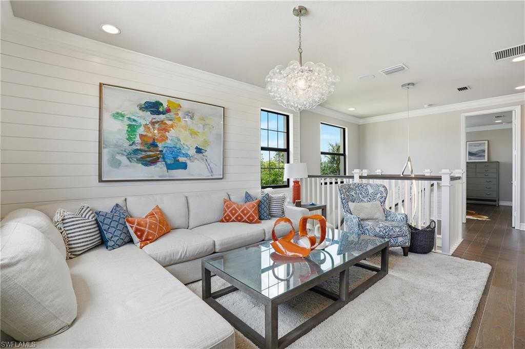 4220 Amelia Way Naples, FL 34119 - Photo 24 of 50 a living room with furniture and a chandelier