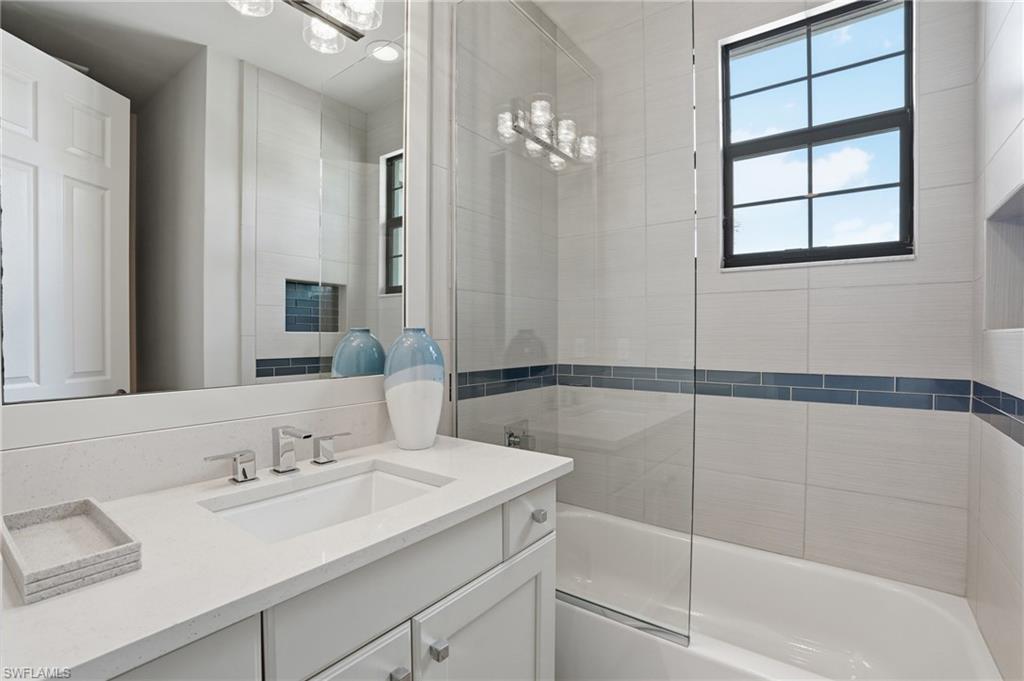4220 Amelia Way Naples, FL 34119 - Photo 30 of 50 a bathroom with a sink and a mirror