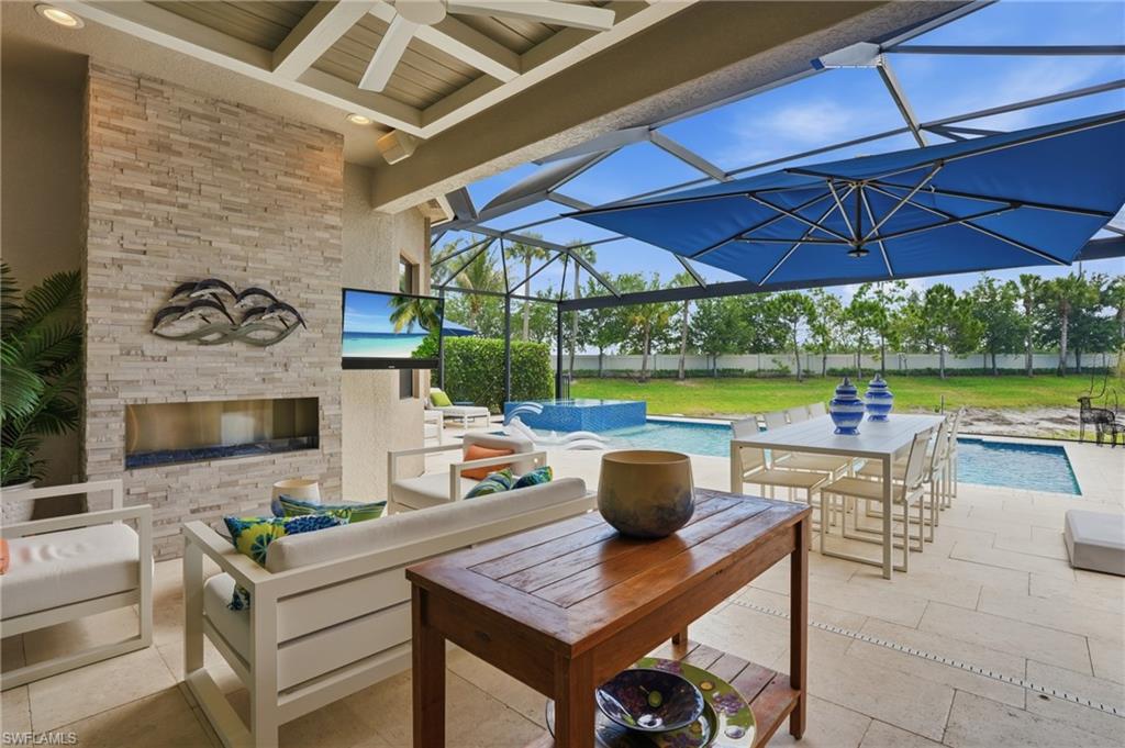 4220 Amelia Way Naples, FL 34119 - Photo 36 of 50 a view of a patio with a table and chairs under an umbrella