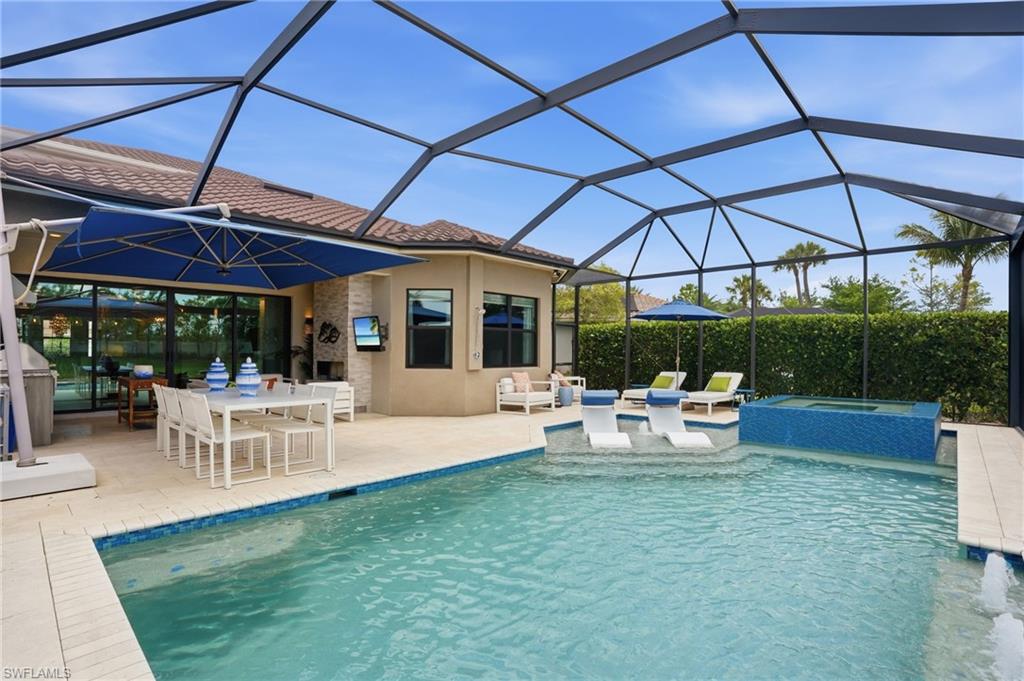 4220 Amelia Way Naples, FL 34119 - Photo 40 of 50 a view of a patio with table and chairs under an umbrella