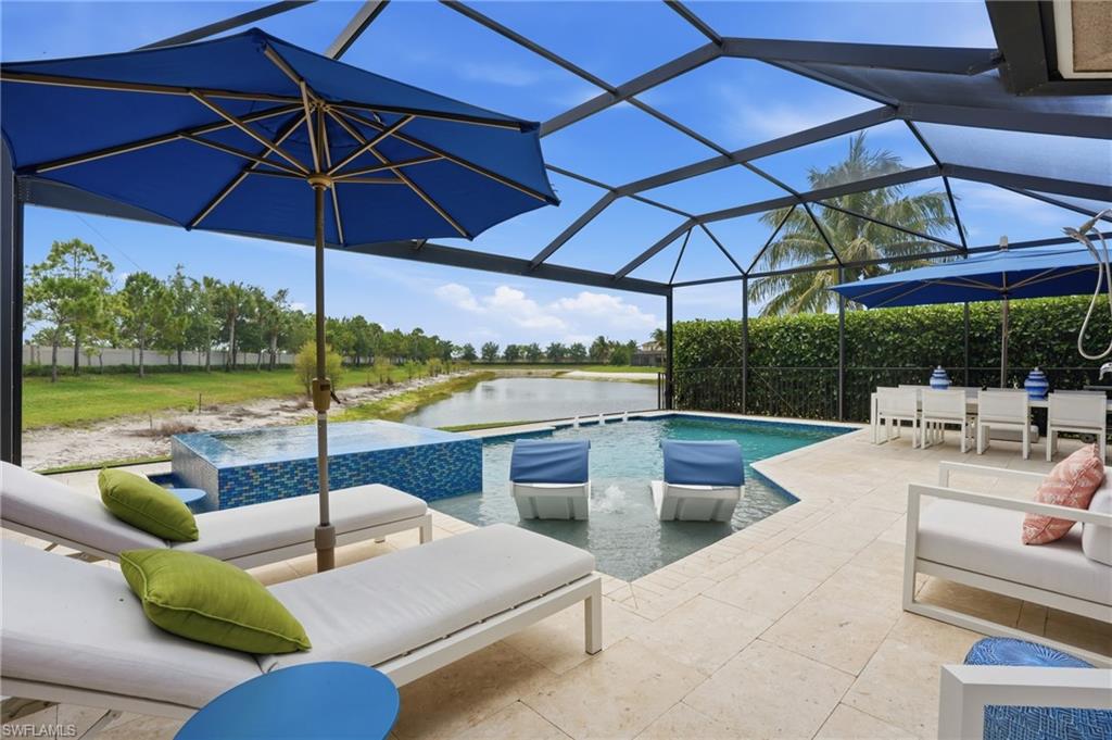 4220 Amelia Way Naples, FL 34119 - Photo 42 of 50 a view of a swimming pool with a couches in a patio