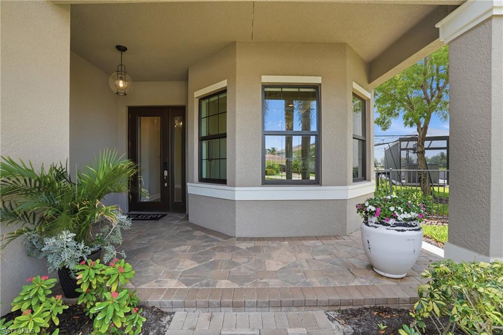 4220 Amelia Way Naples, FL 34119 - Photo 5 of 50 a front view of a house with a garden