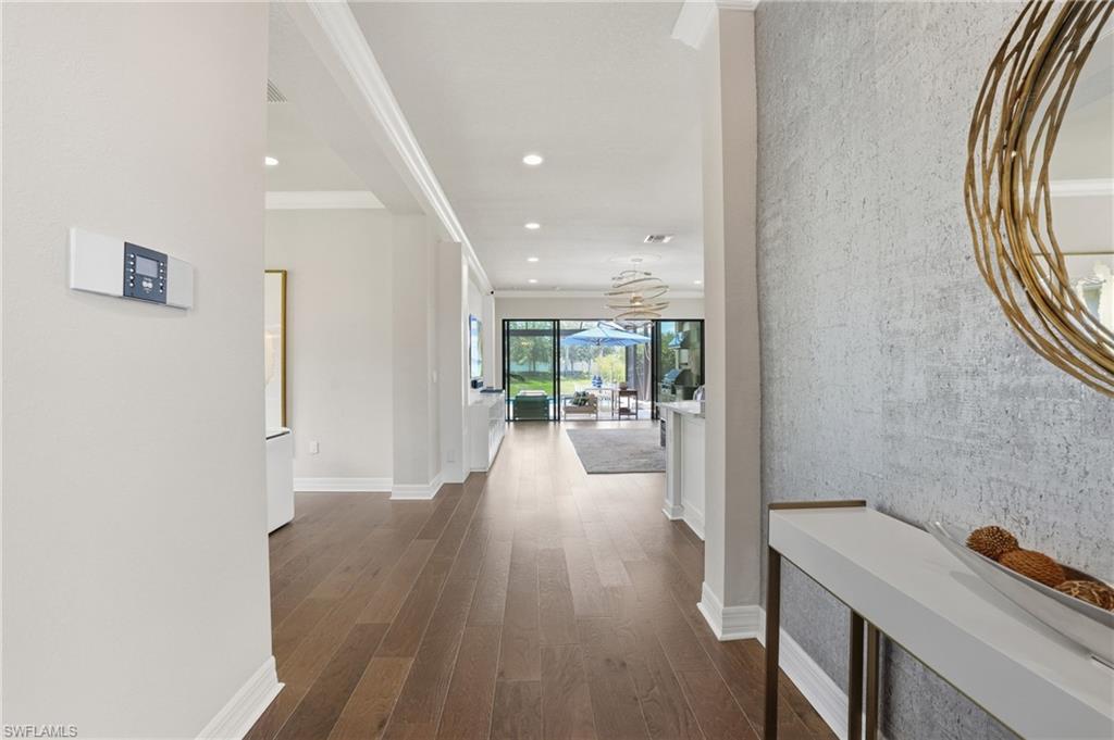 4220 Amelia Way Naples, FL 34119 - Photo 6 of 50 a view of a hallway with wooden floor and furniture